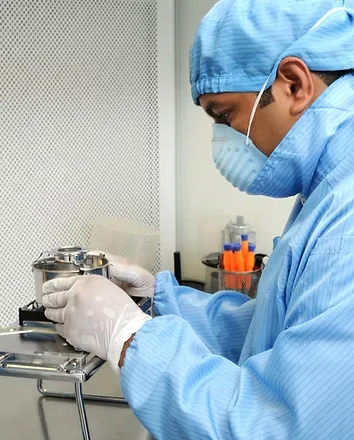 Técnico abriendo un disco duro con guantes en cámara limpia clase 100 de +DR Data Recovery